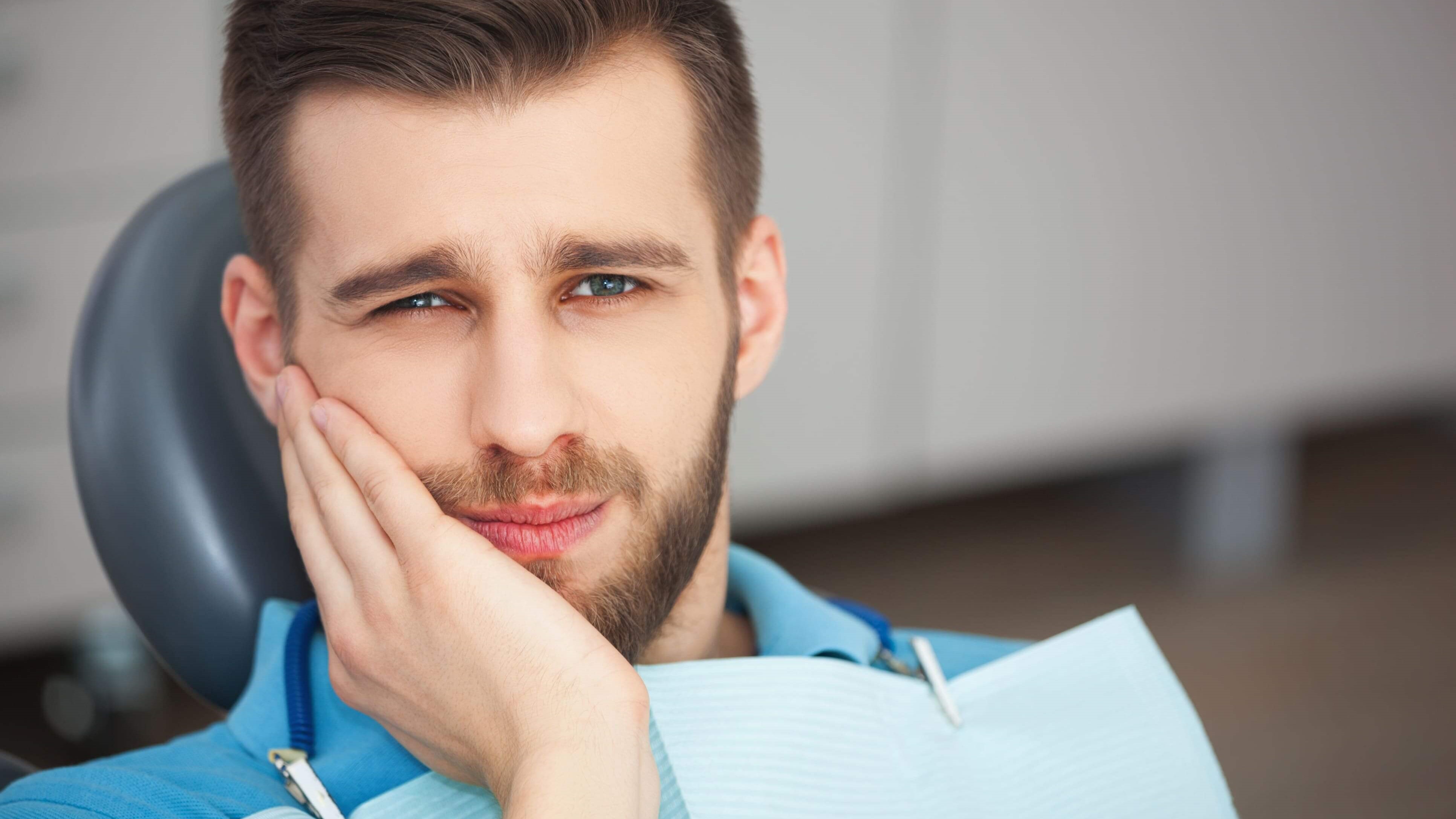 man holding jaw in pain